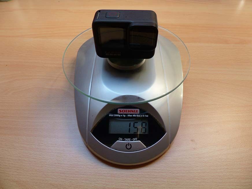 Man sieht, wie das Gewicht der GoPro Hero 9 auf einer Waage gemessen wird. 